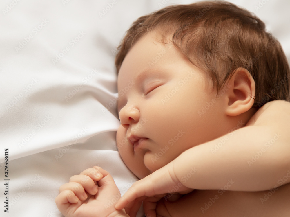 A Baby girl with Smily Face During Sleep. Little baby girl sleeping on white blanket. Beautiful portrait of little child girl 14 days, two weeks old. Motherhood A Baby girl with Smily Face During Sleep. Little baby girl sleeping on white blanket. Beautiful portrait of little child girl 14 days, two weeks old. Motherhood