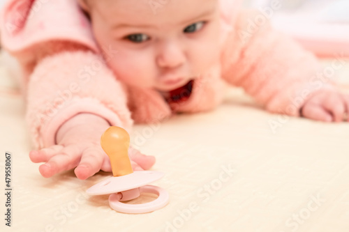 Infant baby trying to get pacifier.