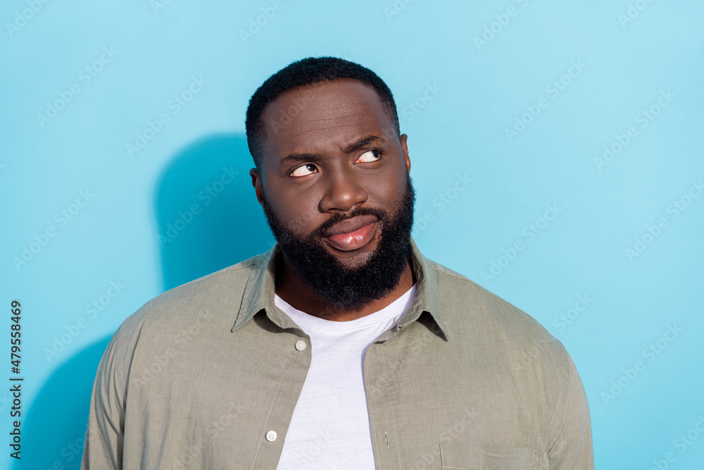 Photo of young african guy interested look empty space think minded isolated over blue color background Photo of young african guy interested look empty space think minded isolated over blue color background