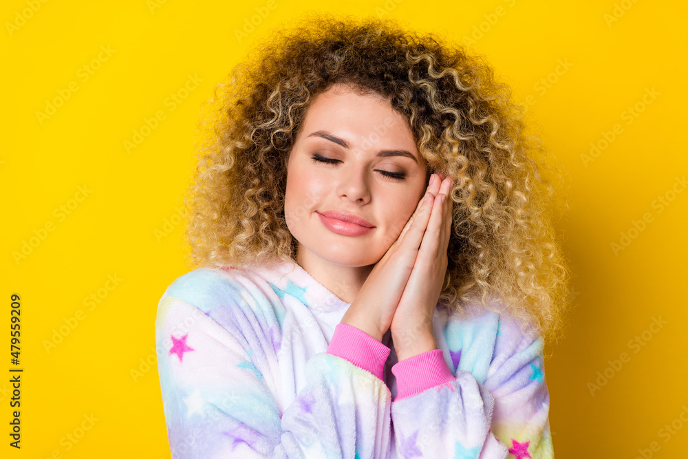 Portrait of attractive calm wavy-haired girl in pajama drowsing asleep isolated over shine yellow color background Portrait of attractive calm wavy-haired girl in pajama drowsing asleep isolated over shine yellow color background
