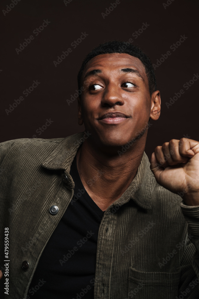 Young black man dressed in shirt smiling and dancing Young black man dressed in shirt smiling and dancing