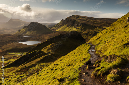 Scenic view of Quiraing mountains in Isle of Skye, Scottish highlands, United Kingdom. Sunrise time with colourful an rayini clouds in background.