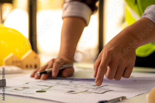 concept architect The engineer is measuring the distance to calculate and holding a pen pointing to the architect's structural schematic document. on the table with blueprints in the office