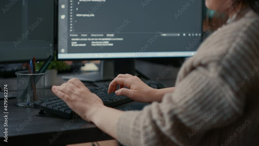 Closeup of caucasian software coder hands typing on keyboard in front of computer screens with programming interface. Database developer sitting at desk writing algorithm for it agency.
