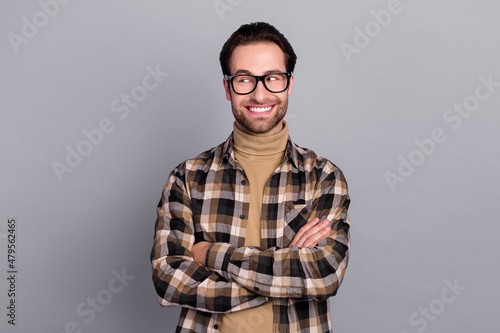 Photo of dreamy clever guy dressed checkered shirt glasses arms folded empty space isolated grey color background © deagreez