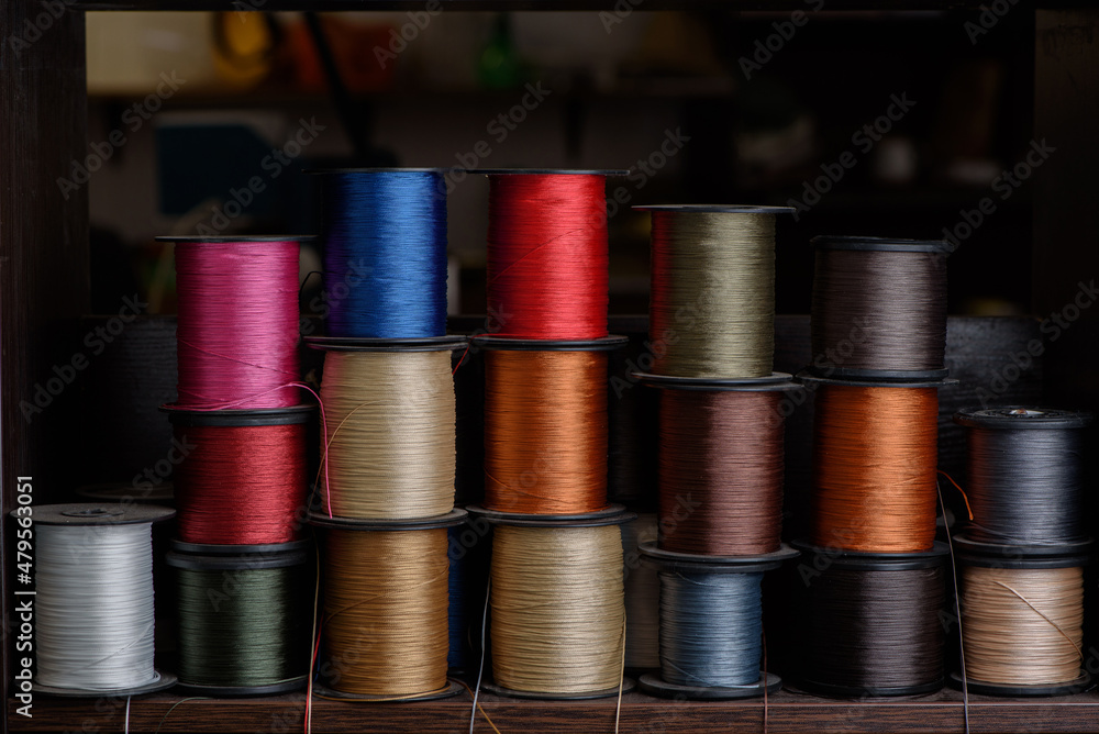 Colored thread spools for shoemaking. Shoe stitching thread in shoemaker workshop.