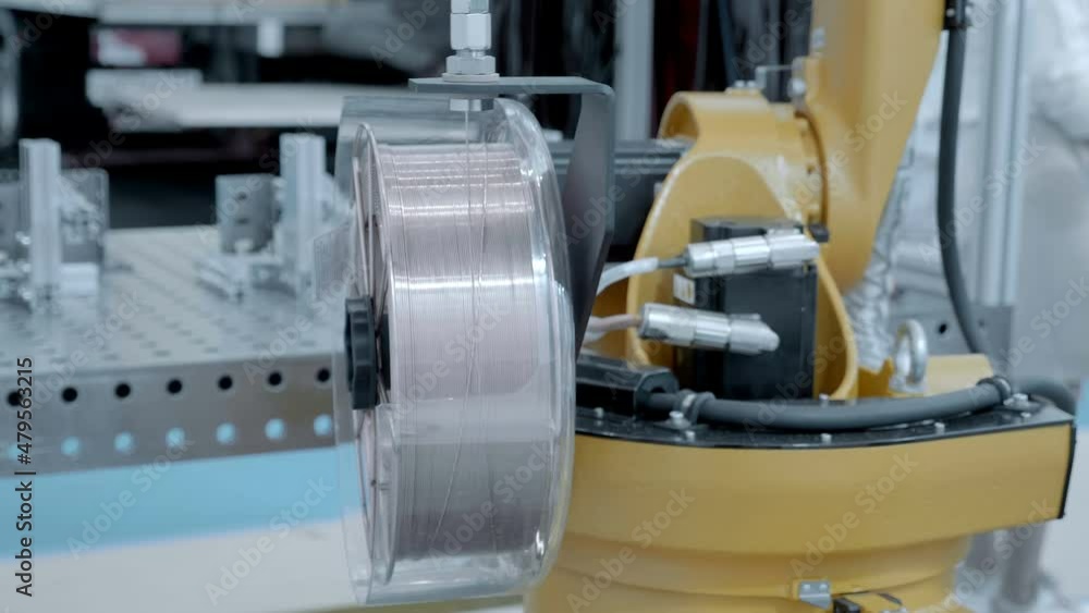 An industrial welding robot demonstrates how the welding of parts fixed on the welding table will take place. Shot in motion. Closeup An industrial welding robot demonstrates how the welding of parts fixed on the welding table will take place. Shot in motion. Closeup