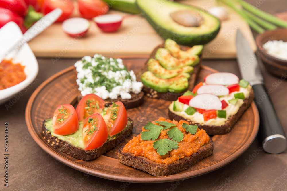 Assortment vegan, vegetarian sandwiches. Healthy homemade sandwich with different vegetables and greens on plate close up Assortment vegan, vegetarian sandwiches. Healthy homemade sandwich with different vegetables and greens on plate close up