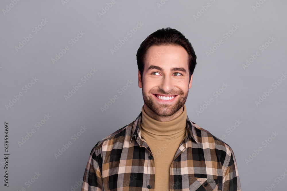 Photo of thoughtful funny guy dressed checkered shirt looking empty space smiling isolated grey color background Photo of thoughtful funny guy dressed checkered shirt looking empty space smiling isolated grey color background