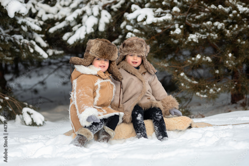Fototapeta premium Two cute kids in winter Russian folk clothes like in a fairy tale
