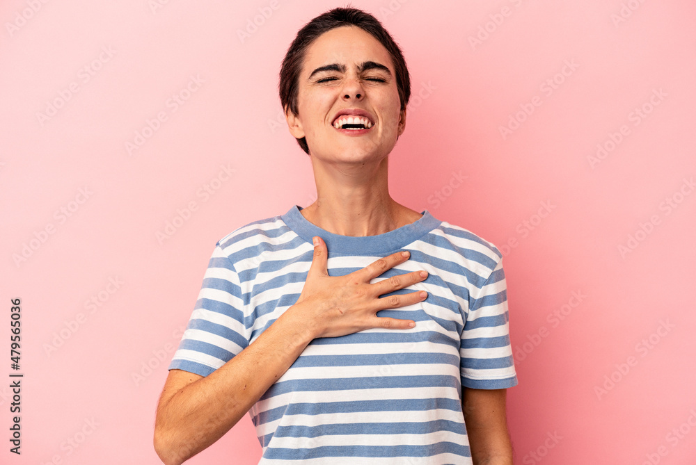 Young caucasian woman isolated on blue background laughs out loudly keeping hand on chest. Young caucasian woman isolated on blue background laughs out loudly keeping hand on chest.