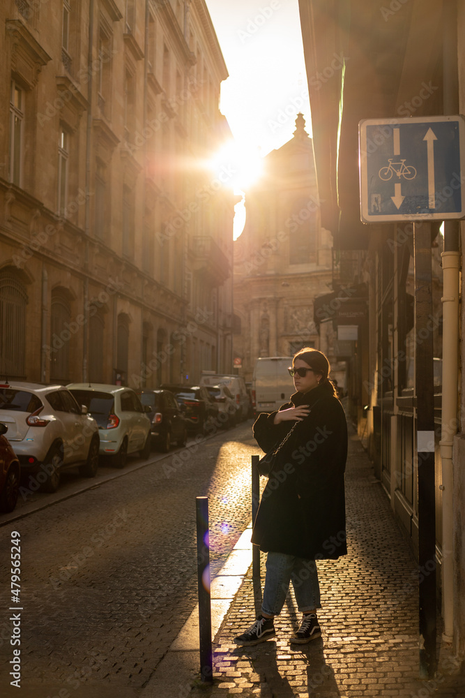 young traveler girl enjoying a sunset through the streets of bordeaux