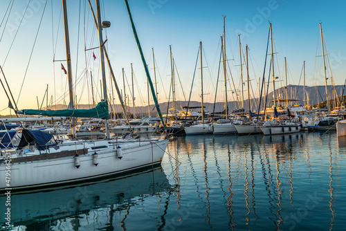 Pier with motorboats and yachts moored alongside at sunset