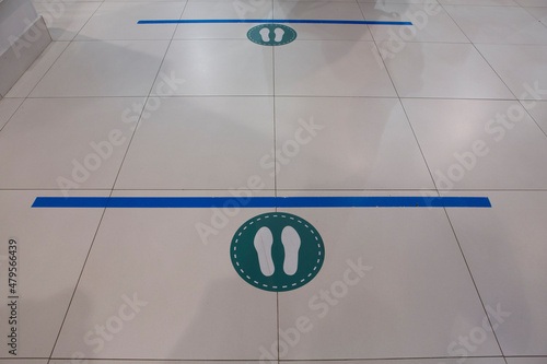 social distancing, keep the distance prevention floor sticker sign with two meters blue line, footsteps circle for queues in a mall shop