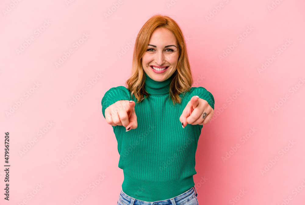 Young caucasian woman isolated on pink background cheerful smiles pointing to front. Young caucasian woman isolated on pink background cheerful smiles pointing to front.