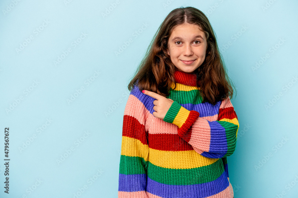 Little caucasian girl isolated on blue background smiling and pointing aside, showing something at blank space. Little caucasian girl isolated on blue background smiling and pointing aside, showing something at blank space.