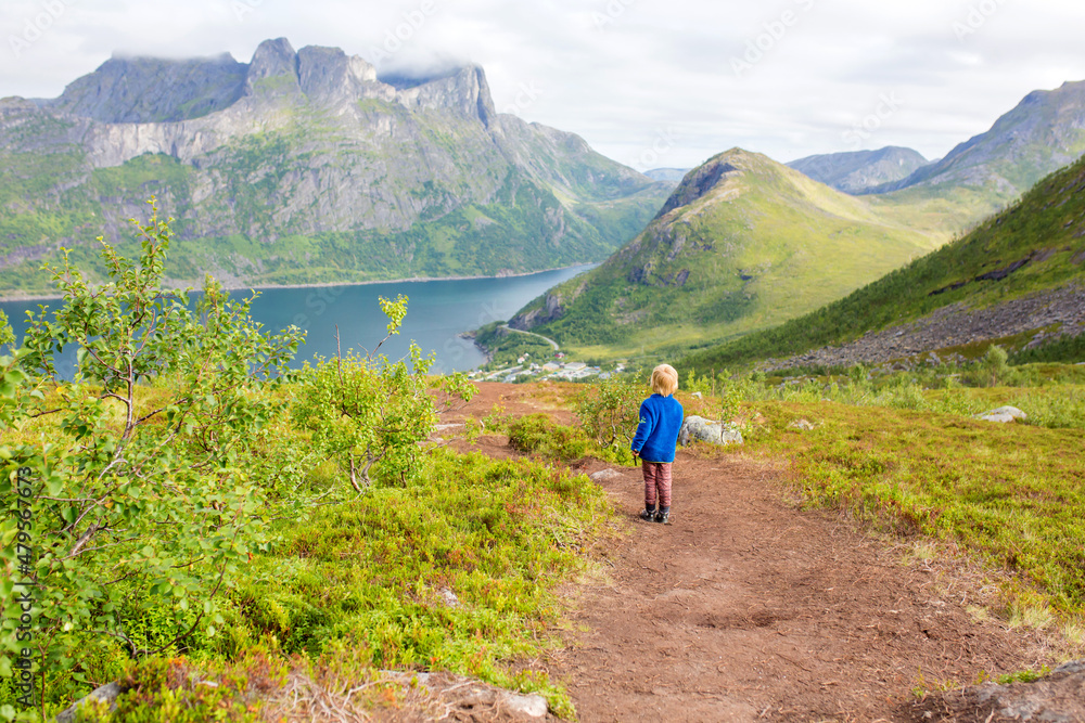 Happy family, standing on a rock and looking over Segla mountain on Senja island, North Norway. Amazing beautiful landscape and splendid nature Happy family, standing on a rock and looking over Segla mountain on Senja island, North Norway. Amazing beautiful landscape and splendid nature