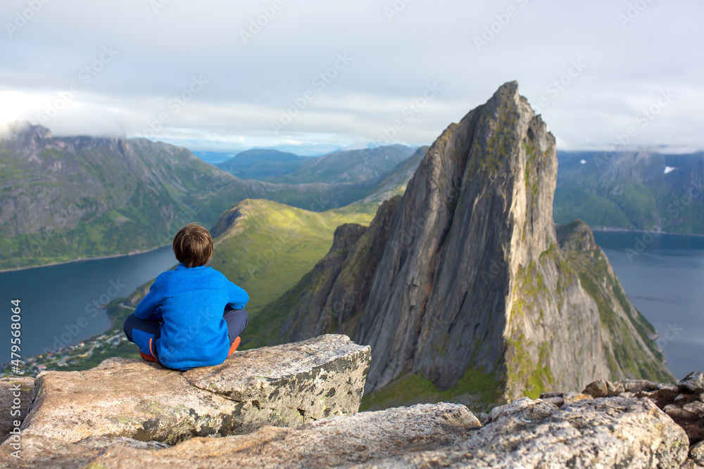 Happy family, standing on a rock and looking over Segla mountain on Senja island, North Norway. Amazing beautiful landscape and splendid nature