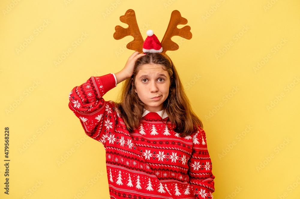 Little caucasian girl wearing a Christmas reindeer hat isolated on yellow background being shocked, she has remembered important meeting. Little caucasian girl wearing a Christmas reindeer hat isolated on yellow background being shocked, she has remembered important meeting.