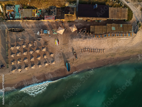 Aerial view of amazing beach with umbrellas and turquoise sea at sunrise. Black Sea at Vama Veche, Romania photo