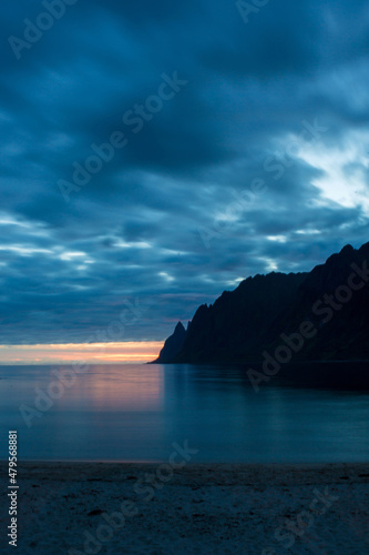 Children, enjoying sunset on Ersfjord Beach on Senja island, beautiful landscape view over the mountains