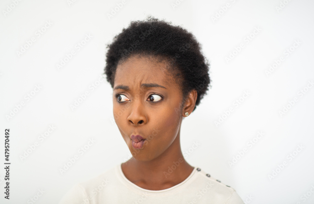 Close up young African American woman surprised expression by white isolated background Close up young African American woman surprised expression by white isolated background