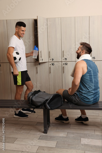 Handsome athletic men talking in locker room