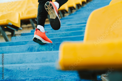 Young sportsman running up the stairs while working out at stadium