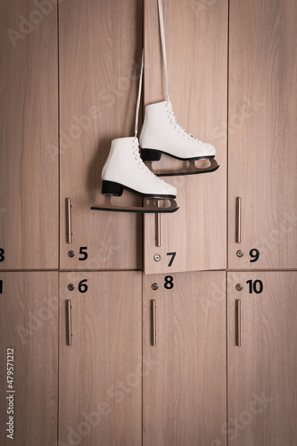 Εκτύπωση καμβά Ice skater boots hanging on locker door in changing room