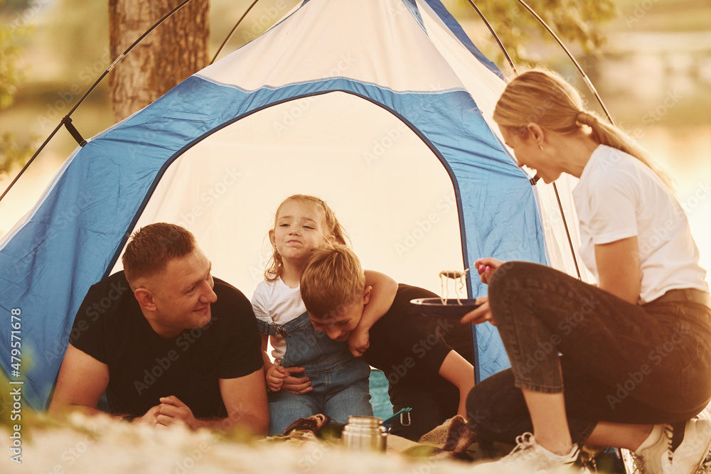 Conception of vacation. Family of mother, father and kids is on the camping