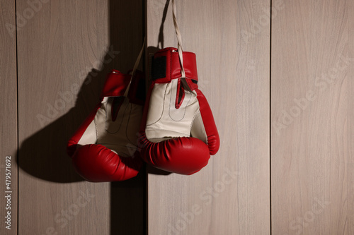Red boxing gloves hanging on locker door in changing room © New Africa