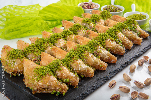 Sobiyet baklava on a marble background. Turkish patisserie dessert with pistachio baklava. Ramadan or holiday desserts concept. Antep Baklavasi. local name; Sobiyet Baklava. photo