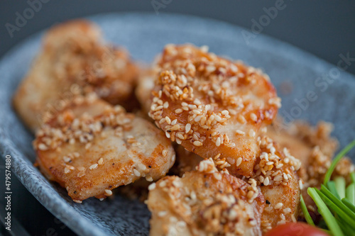asian sesame chicken dish on a plate with garlic sprouts