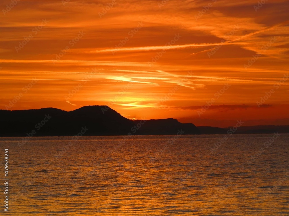 beautiful orange sky over the cliffs and sea at sunrise	
