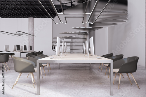 Contemporary concrete coworking office interior with furniture and spiral stairscase. 3D Rendering.