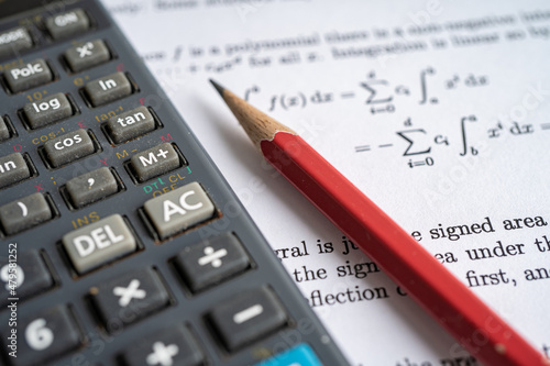 Pencil and calculator on mathematic formula exercise test paper in education school.