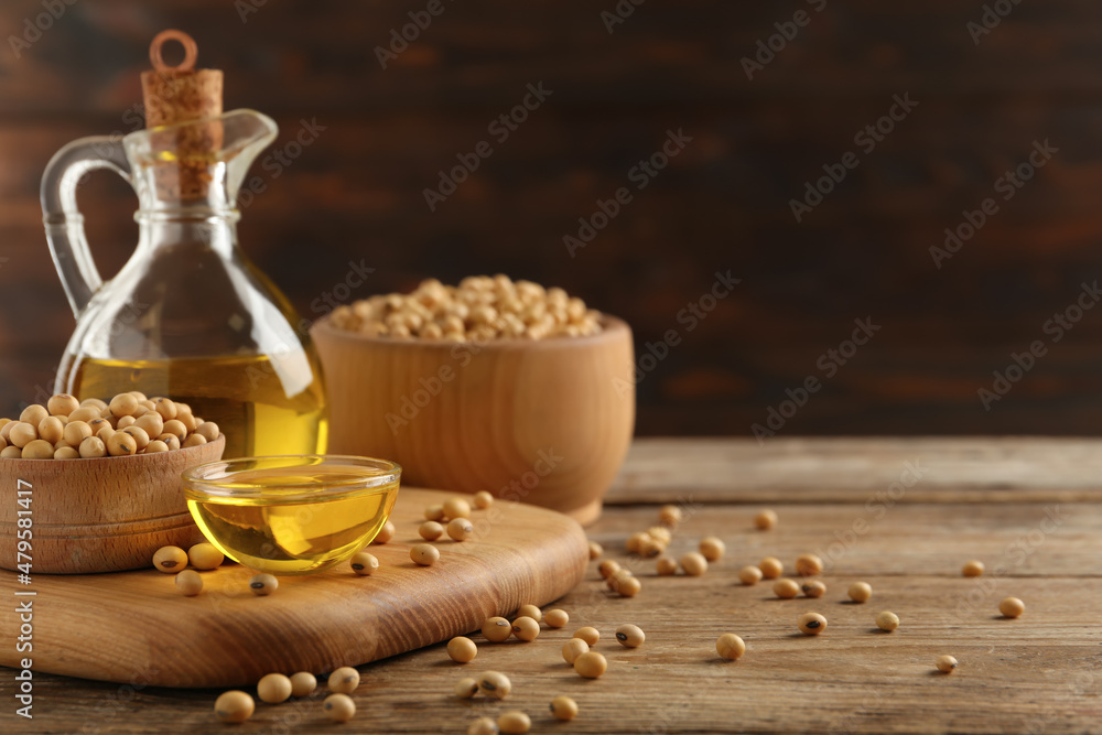 Composition with soybean oil on wooden table, space for text