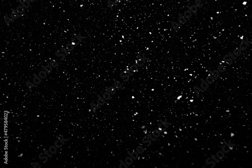 Falling snow freeze motion in the dark sky. Texture isolated on black background. Perfect for white snowflakes overlay  winter abstract
