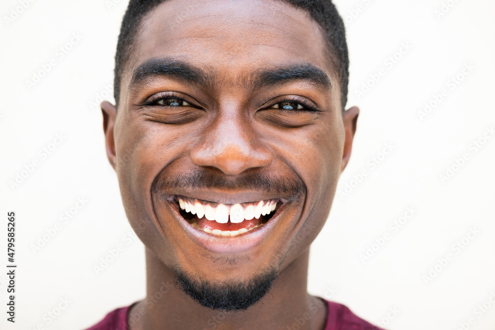 Fototapeta premium Close up happy young african American man laughing against white background