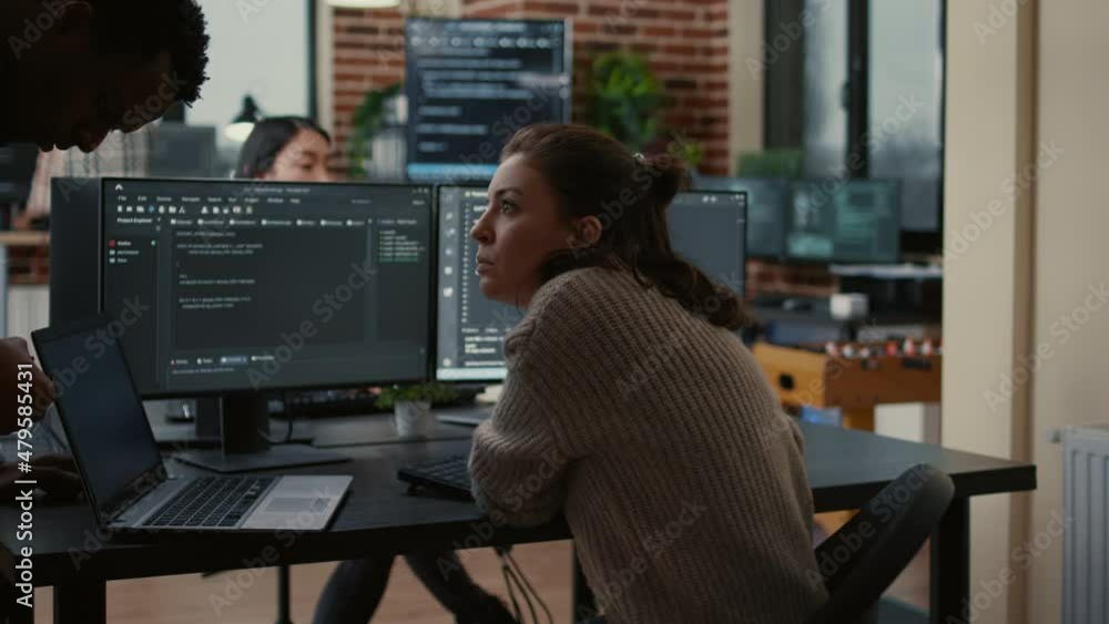 Junior developer putting laptop with source code on senior dev desk asking for opinion about database. Programer writing algorithm interrupted by colleague wanting help with fixing errors. Junior developer putting laptop with source code on senior dev desk asking for opinion about database. Programer writing algorithm interrupted by colleague wanting help with fixing errors.