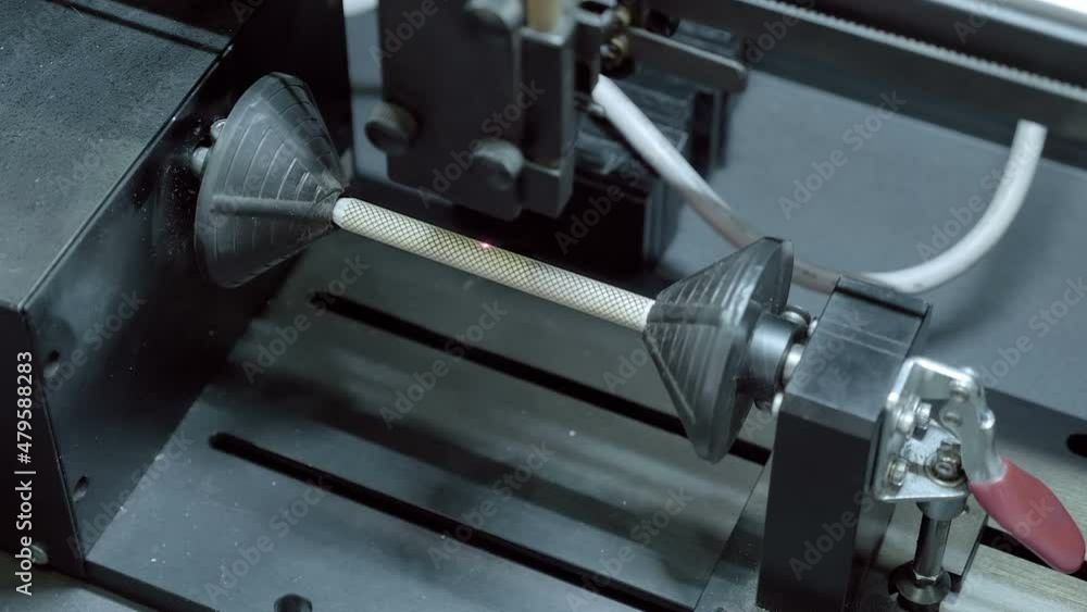 The equipment works according to the program and burning pattern on a wooden rod by means of a laser. Closeup The equipment works according to the program and burning pattern on a wooden rod by means of a laser. Closeup