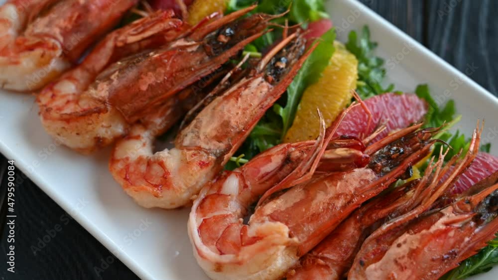 Grilled tiger prawns or shrimps with orange grapefruit and greens on a plate Grilled tiger prawns or shrimps with orange grapefruit and greens on a plate