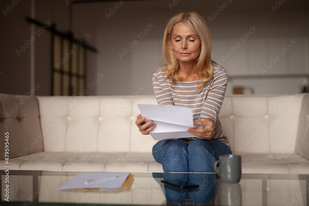 Postal advertising, promotion. Mature woman reads a letter at home. Corporate reply by mail. Postal advertising, promotion. Mature woman reads a letter at home. Corporate reply by mail.