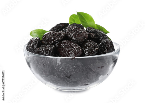 Bowl with sweet dried prunes and green leaves isolated on white