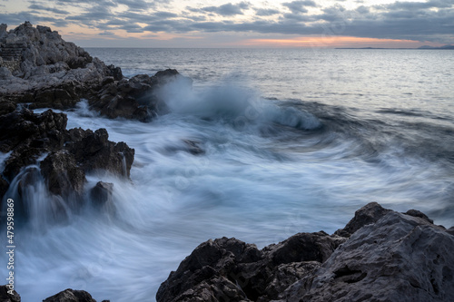 Paysage marin du rivage méditerranéen au Cap de Nice en hiver avec des vagues et des rochers au coucher du soleil