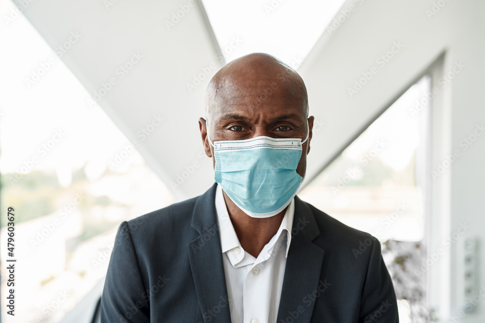 Portrait of businessman in medical mask in office