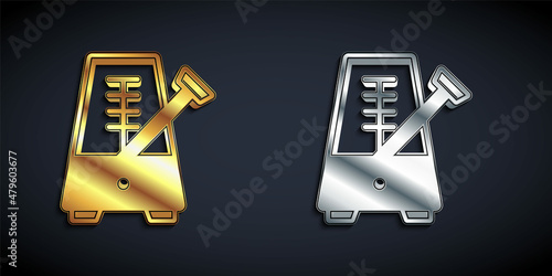 Gold and silver Classic Metronome with pendulum in motion icon isolated on black background. Equipment of music and beat mechanism. Long shadow style. Vector