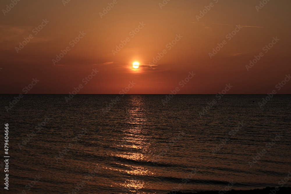 Romantic sunset over baltic sea at a pebble beach