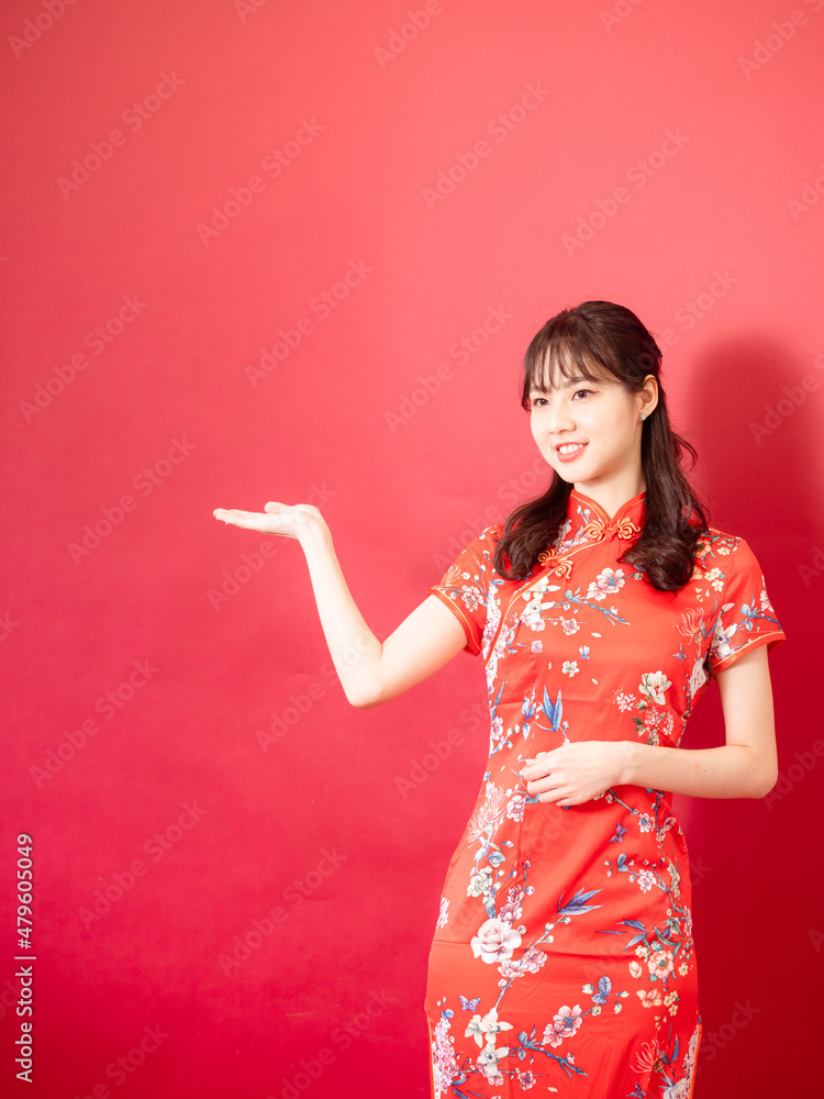Chinese teen girl in present show giving or sale promotion posture dressing cheongsam. Chinese teen girl in present show giving or sale promotion posture dressing cheongsam.