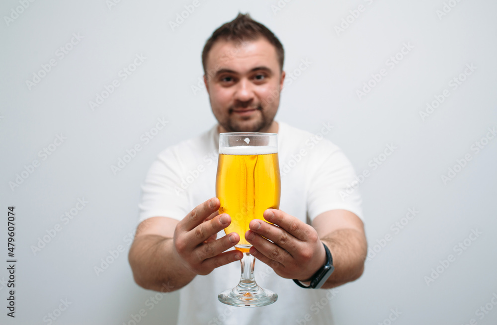 Positive bearded fat guy with a big glass of beer and smiling. Funny young man feeling happy and relaxed, with cold fresh beer in his hands after a hard day at work Positive bearded fat guy with a big glass of beer and smiling. Funny young man feeling happy and relaxed, with cold fresh beer in his hands after a hard day at work